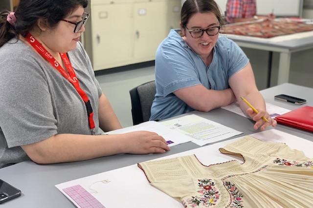 Introduction to Textile Conservation participants conducting a detailed condition report on a Mexican blouse from the Logan Museum's coll...